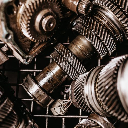 A closeup shot of dirty metal gears on a grid under light